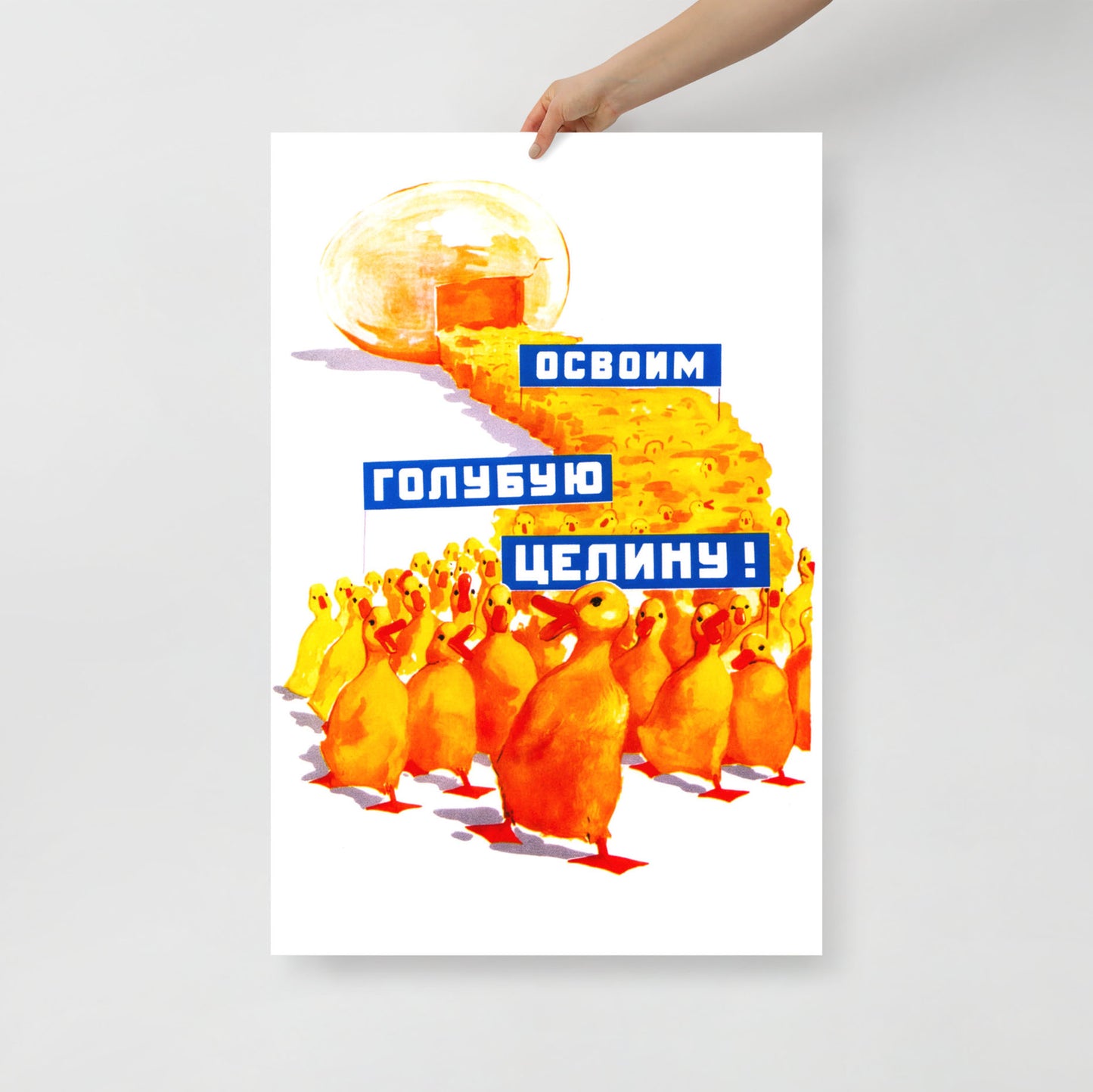A hand holding original Soviet propaganda large poster showing yellow ducklings marching from an egg carrying banners reading "Освоим голубую целину" (Let's Develop the Blue Virgin Lands), colourful Soviet agricultural development artwork featuring ducks and aquatic resource symbolism. Ships worldwide from www.artsoviet.com