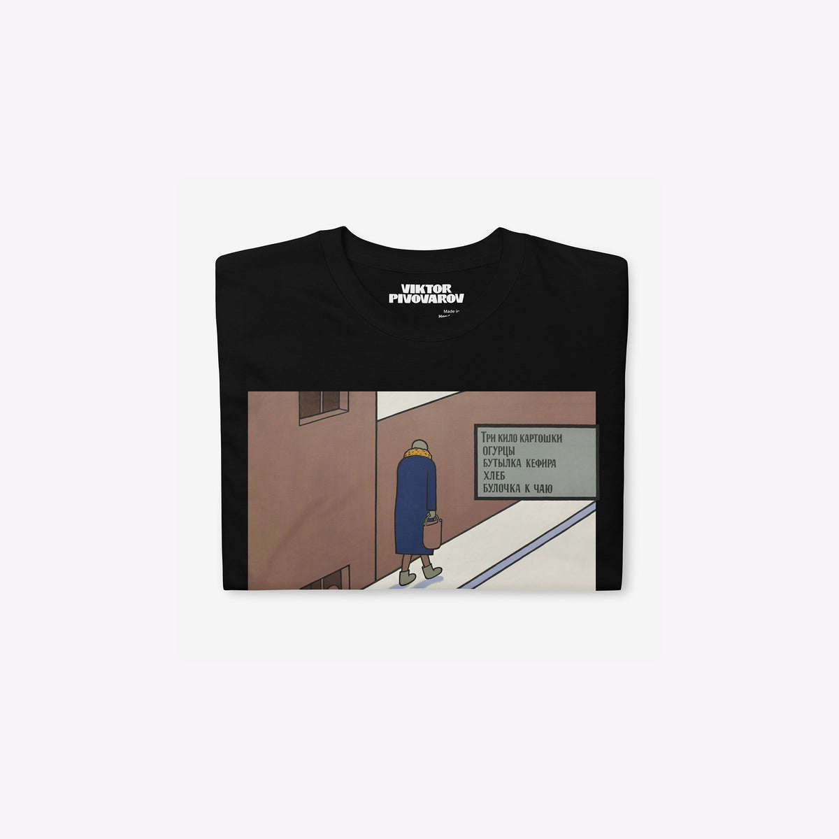 Black unisex T-shirt featuring Viktor Pivovarov’s Soviet conceptual artwork ‘A bun for tea’. Folded