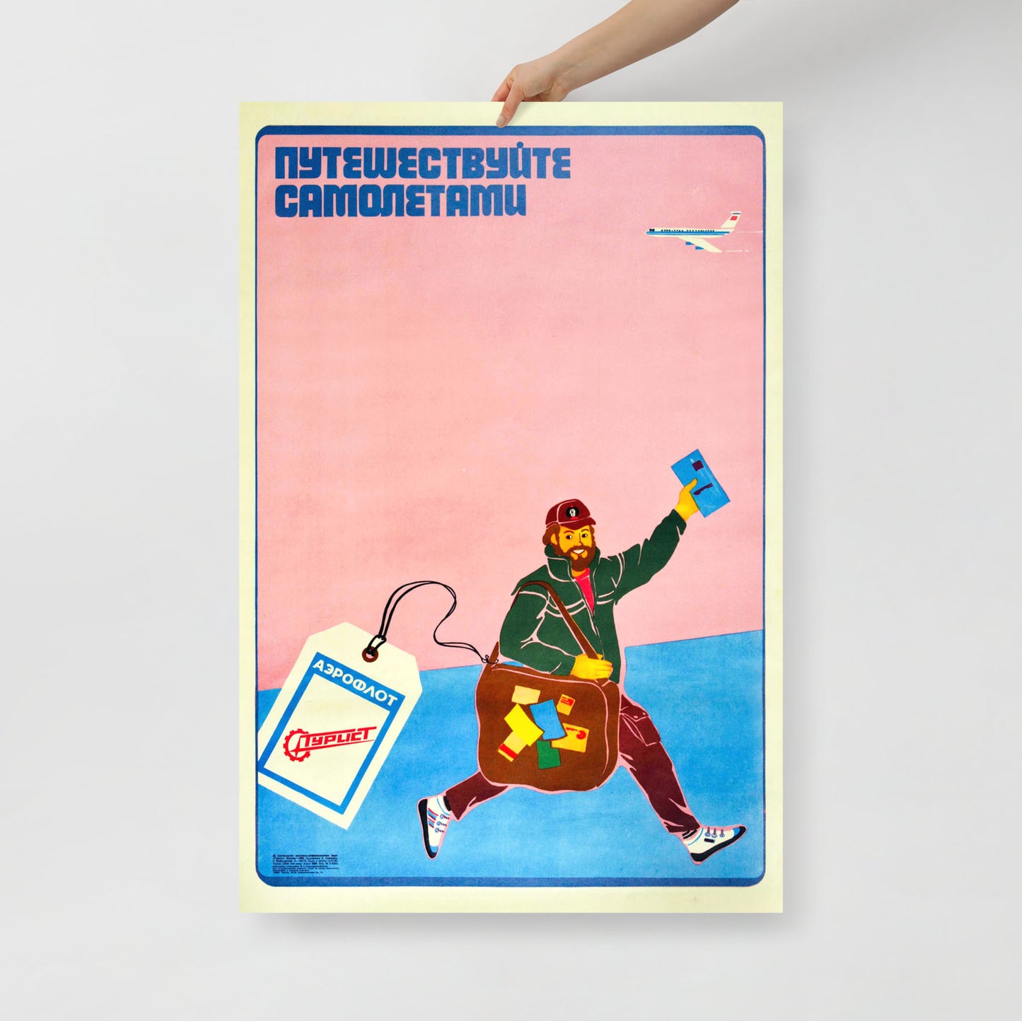 A hand holds large vintage Soviet Aeroflot travel poster by Semchenko, smiling man running below airplane, USSR aviation art reproduction. www.artsoviet.com