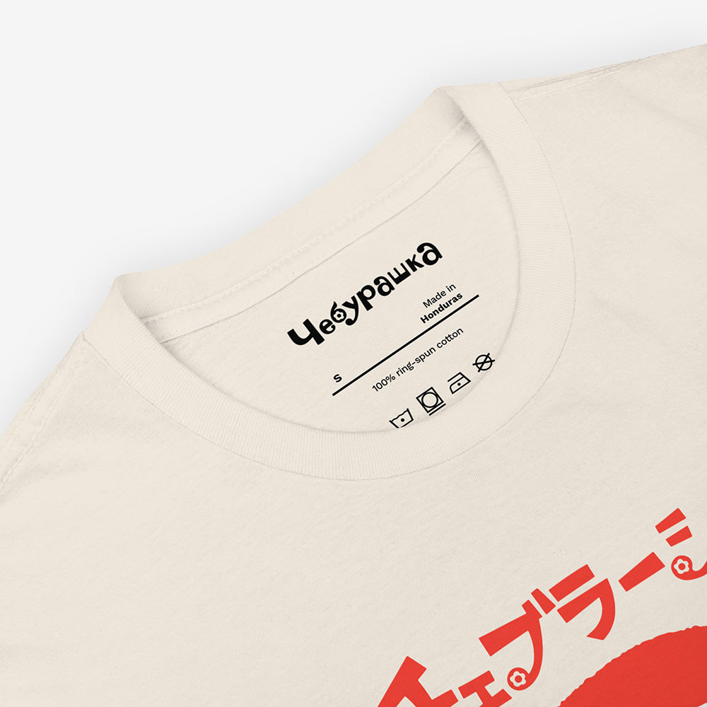 White unisex T-shirt with Soviet cartoon Cheburashka smiling and チェブラーシカ in Japanese above.