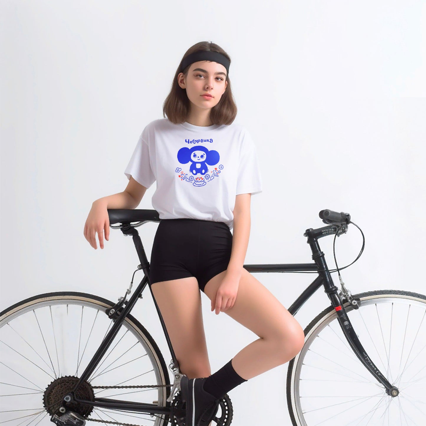 Young attractive teenage girl in short shorts wearing iconic Cheburashka with birthday cake unisex white T-shirt