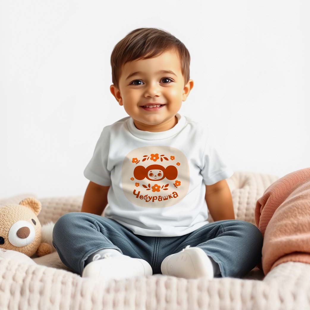 Cute baby boy wearing Cheburashka baby T-shirt featuring the beloved Soviet cartoon character with a floral design, inspired by vintage USSR animation.