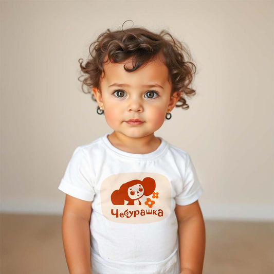 Cute baby girl wearing Cheburashka baby T-shirt featuring the beloved Soviet cartoon character with a flowers. Iconic USSR animation.
