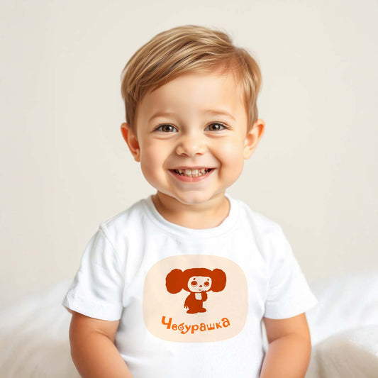 Cute baby boy wearing Cheburashka baby T-shirt featuring the classic Soviet cartoon character in a shy, adorable pose, inspired by vintage USSR animation.