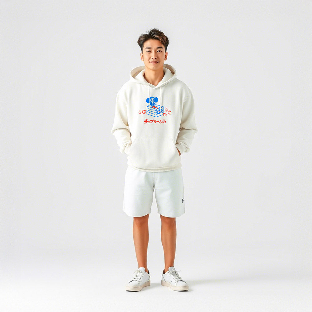 Cool japanese boy wearing white unisex hoodie with a print of Soviet cartoon Cheburashka on a box of oranges with チェブラーシカ text in Japanese.