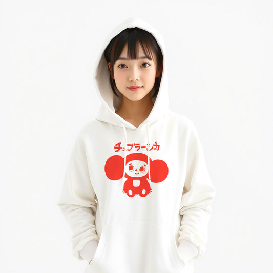 Cute japanese girl wearing white unisex hoodie with a print of Cheburashka smiling and チェブラーシカ text in Japanese.