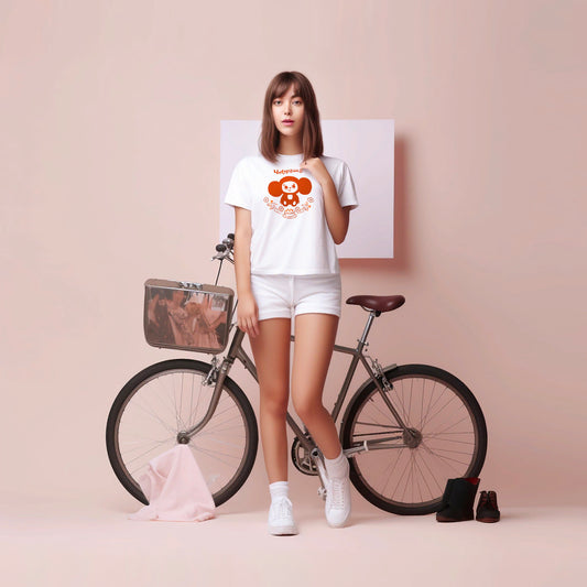 Cute young girl in short shorts wearing white unisex t-shirt with Cheburashka with birthday cake printed in brown colors