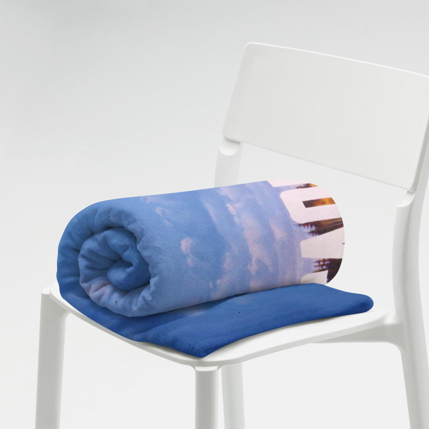 Large blanket with Erik Bulatov painting 'Do not lean depicting white text 'Не прислоняться' over an autumn birch forest. Lying rolled on chair. www.artsoviet.comw