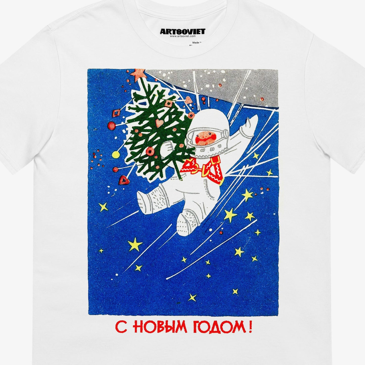 White unisex T-shirt with a vintage Soviet Happy New Year graphic featuring a  cute cosmonaut kid floating in space and holding a Christmas tree. С Новым Годом text in Cyrillic underneath. Closeup photo. www.artsoviet.com