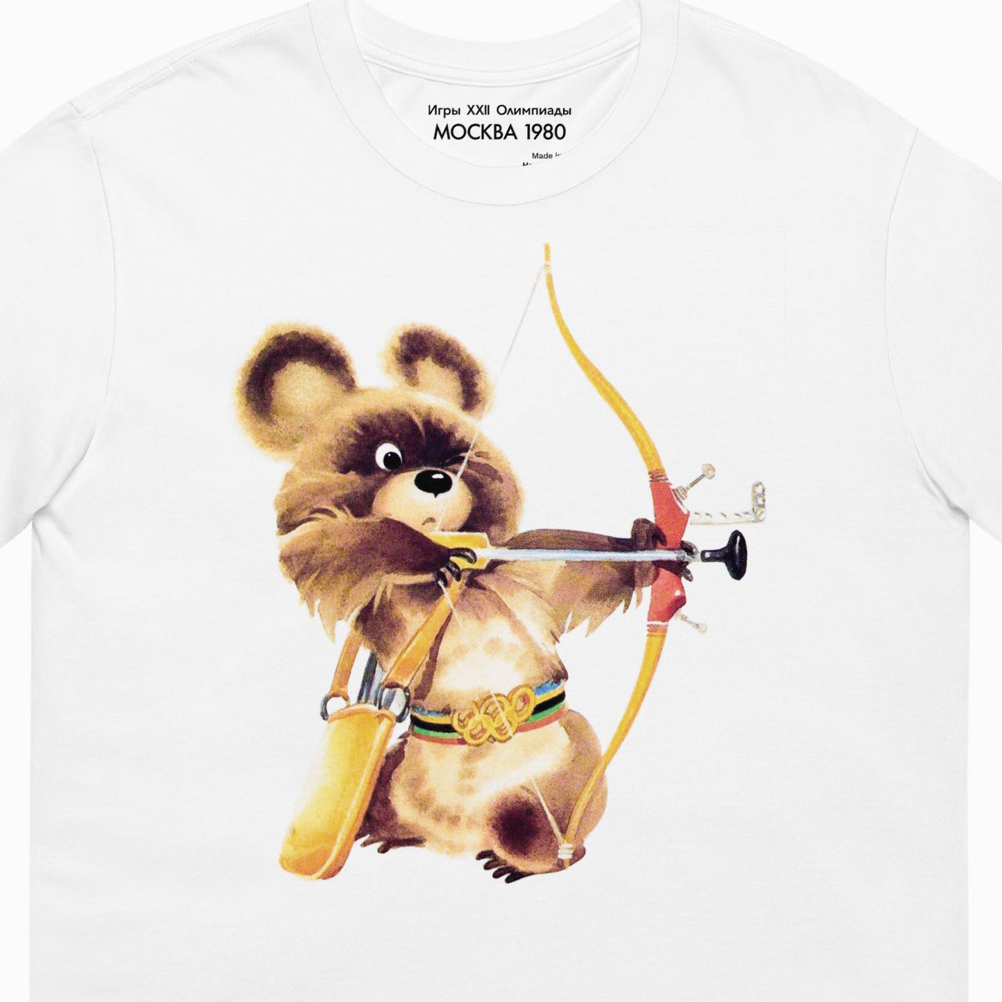 White unisex tee with large official USSR Moscow 1980 Olympics Bear Misha mascot as an archer. МОСКВА 1980 logo on the necktag. Original design sourced from private archives. Exclusive Soviet Olympic Games collectible. Ships worldwide. Closeup print details. www.artsoviet.com