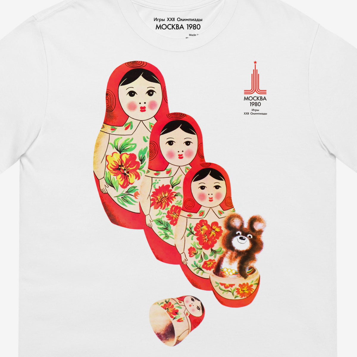 White unisex vintage T-shirt featuring Moscow 1980 Soviet mascot bear Misha and Matryoshka dolls. Official vintage USSR sport games promotion art. Closeup