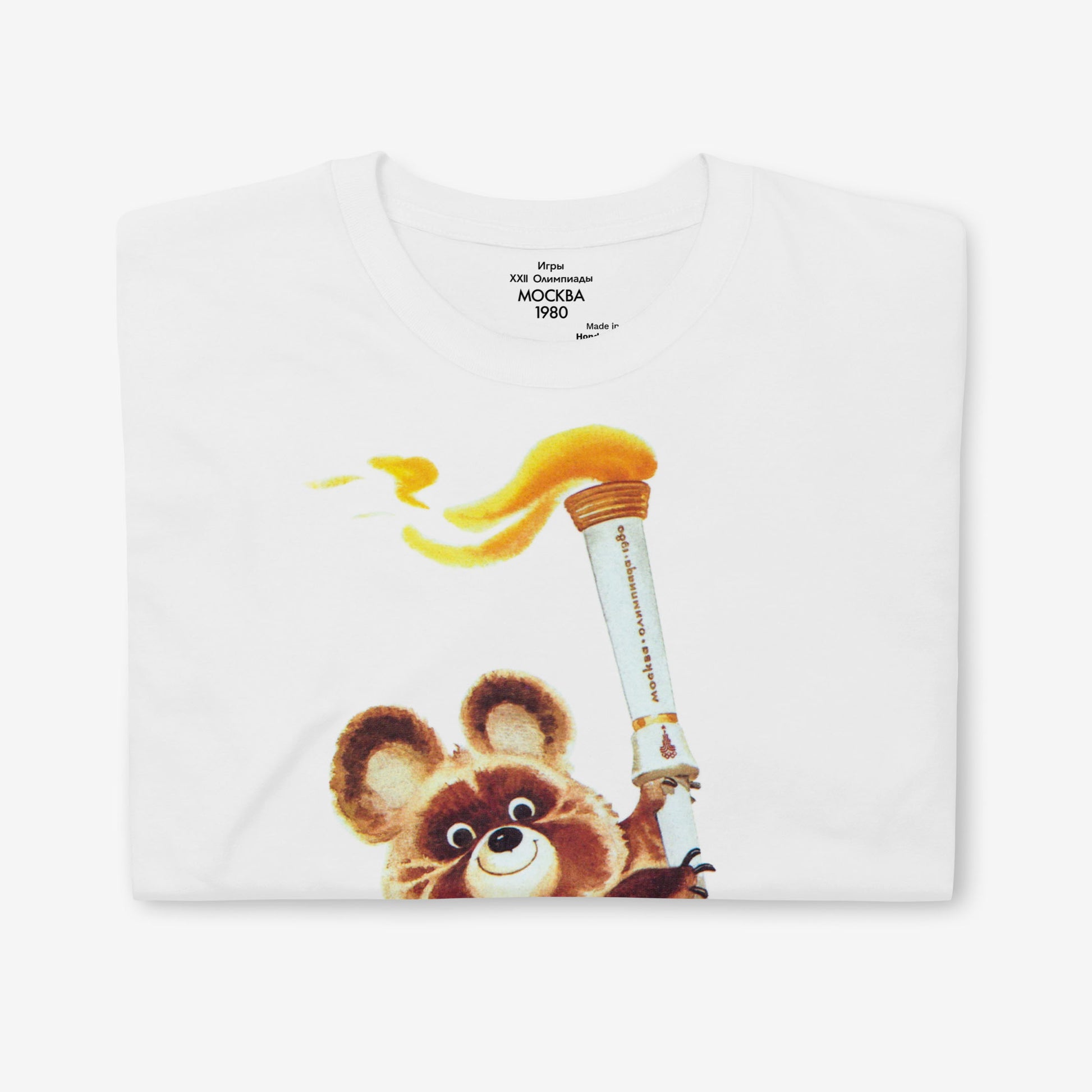 Misha the Olympic Bear unisex T-shirt featuring the iconic 1980 Moscow Olympics design with the Olympic torch, celebrating Soviet sports history. Folded. www.artsoviet.com