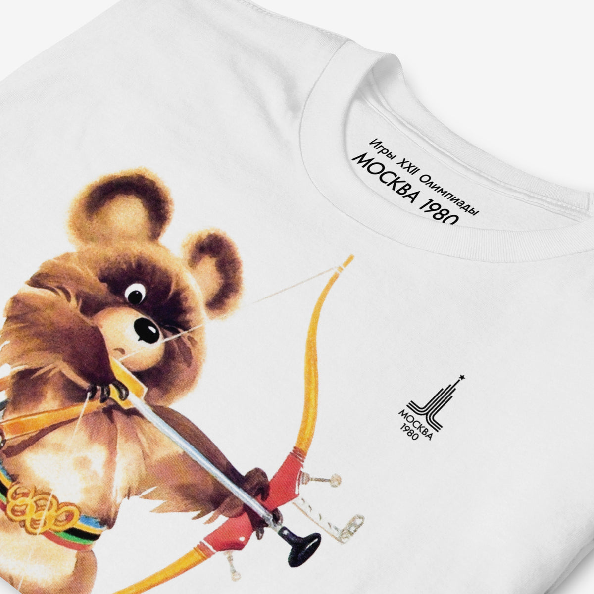 White unisex T-shirt featuring large official USSR Moscow 1980 mascot bear Misha as an archer. Exclusive Soviet collectible. Ships worldwide. Closeup print details