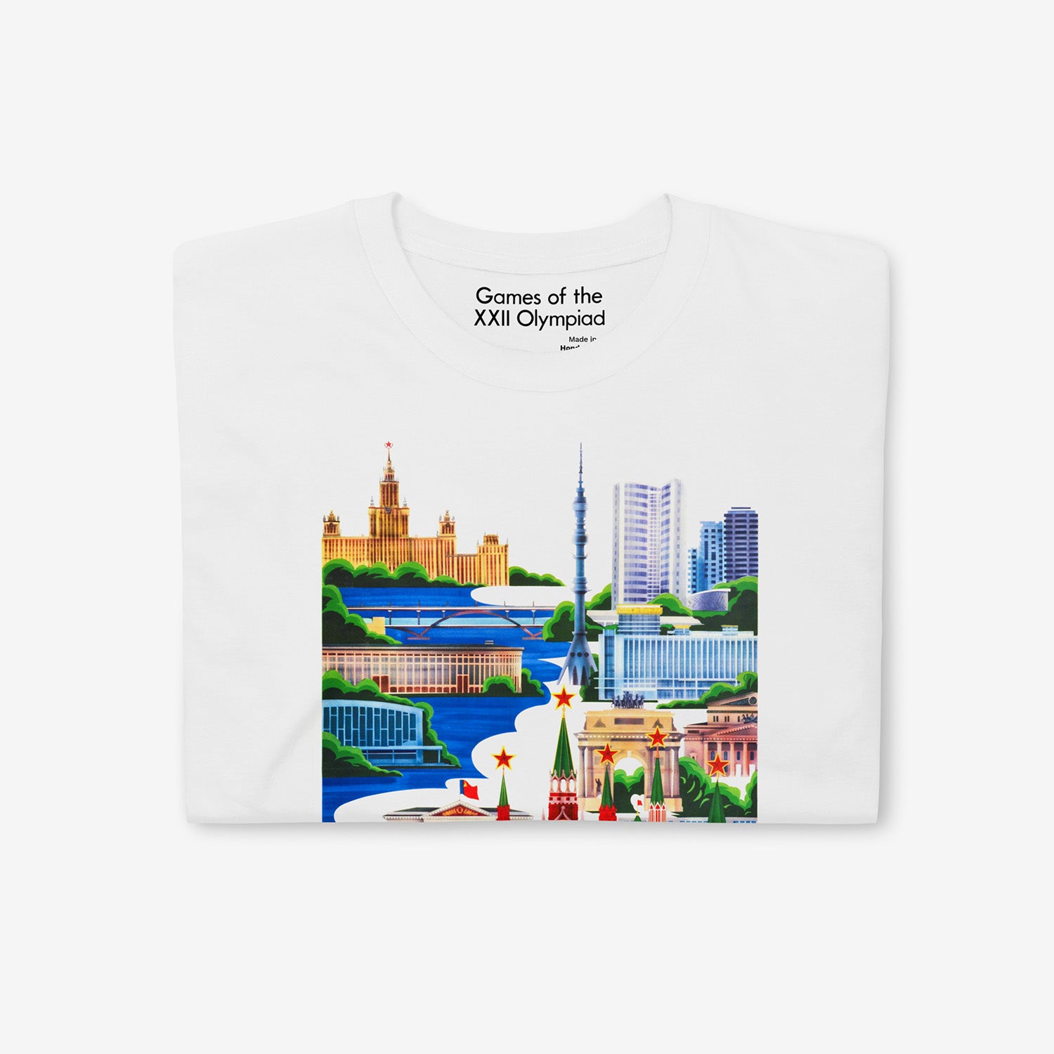Unisex white T-shirt with Moscow 1980 Olympic Games art featuring Kremlin, Ostankino Tower, and Moscow landmarks. Closeup photo also showing custom necktag design with text "Games of the XXII Olympiad". www.sovisual.art