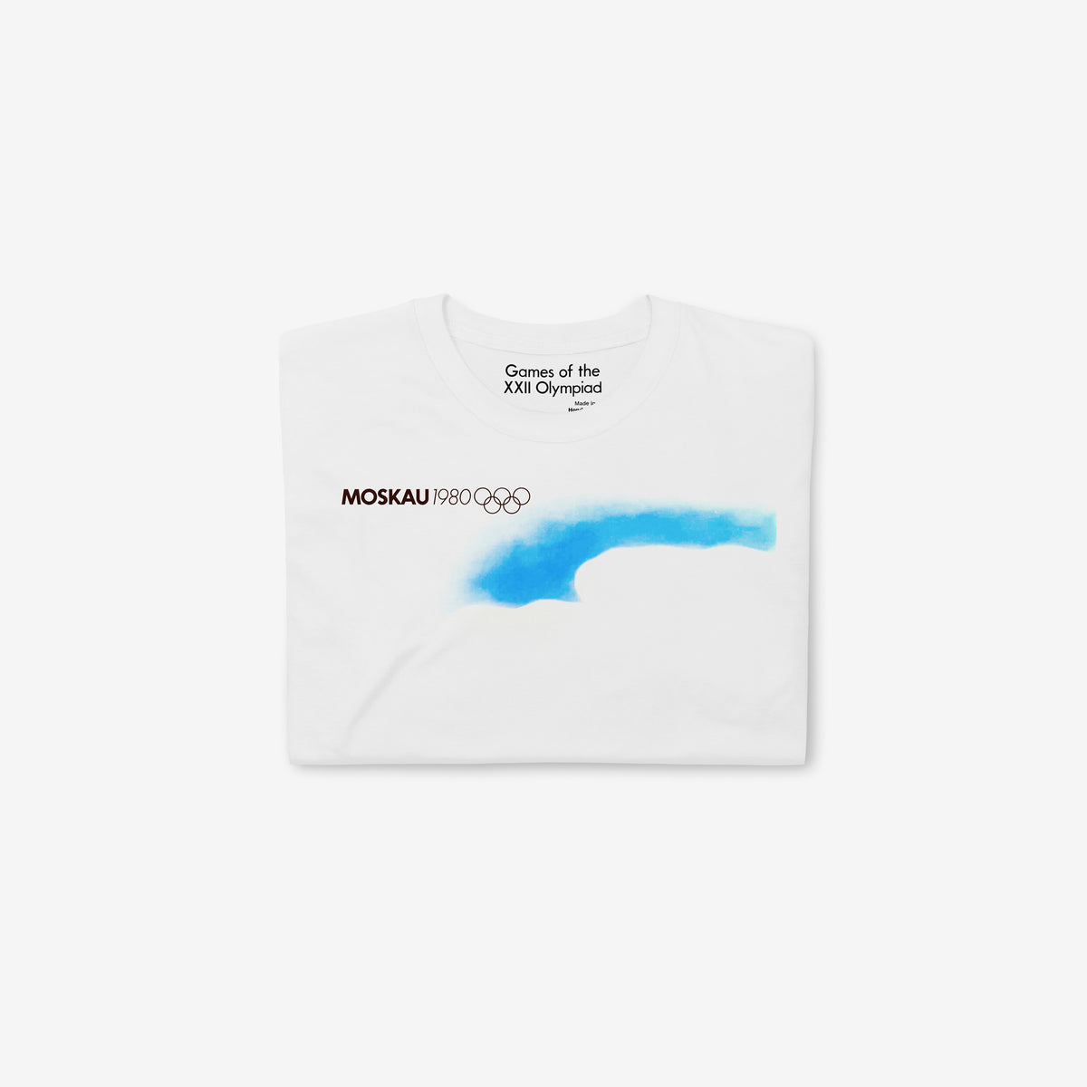 T-shirt featuring original vintage Soviet Olympic Games promotion art with text MOSCAU 1980, Olympic logo and minimalist composition with rising sun and roads made of stylised Moscow Olympics logo going towards it. Folded