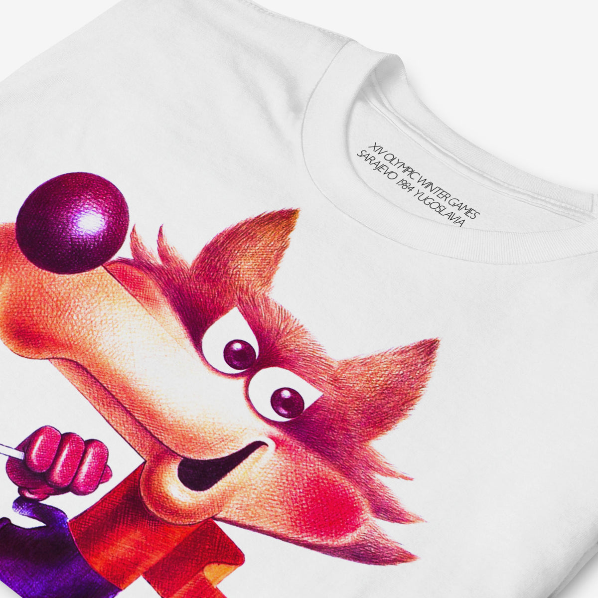 Yugoslavia Olympic Games white unisex T-shirt featuring large print of the official Sarajevo 1984 Winter Olympics mascot Vučko skier. Closeup photo.