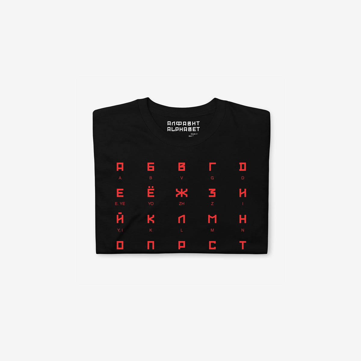Black Tee featuring large Russian alphabet in a bold Soviet-style font. With english pronunciation beneath each letter. Folded