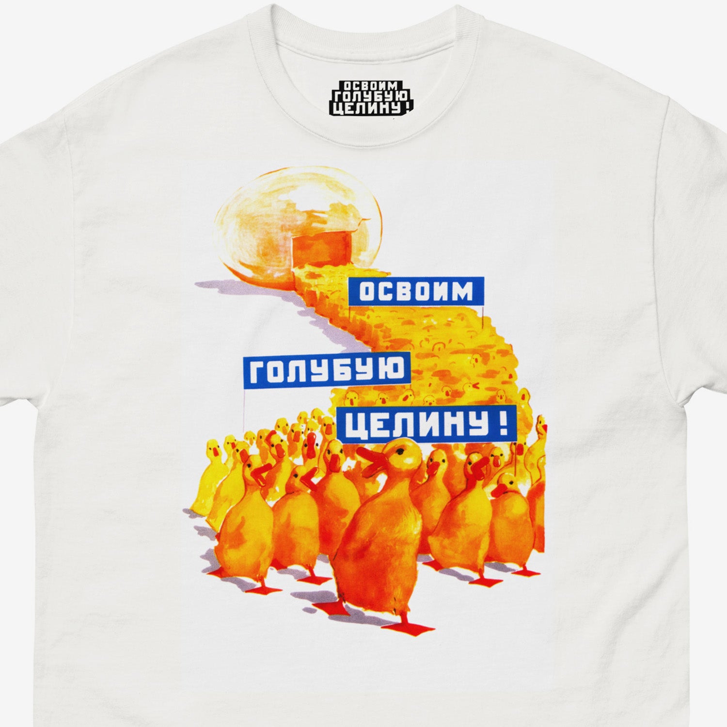 White unisex tee with original large print Soviet propaganda showing yellow ducklings marching from an egg carrying banners reading "Освоим голубую целину" (Let's Develop the Blue Virgin Lands), colourful Soviet agricultural development artwork featuring ducks and aquatic resource symbolism. Closeup print details. Ships worldwide from www.artsoviet.com
