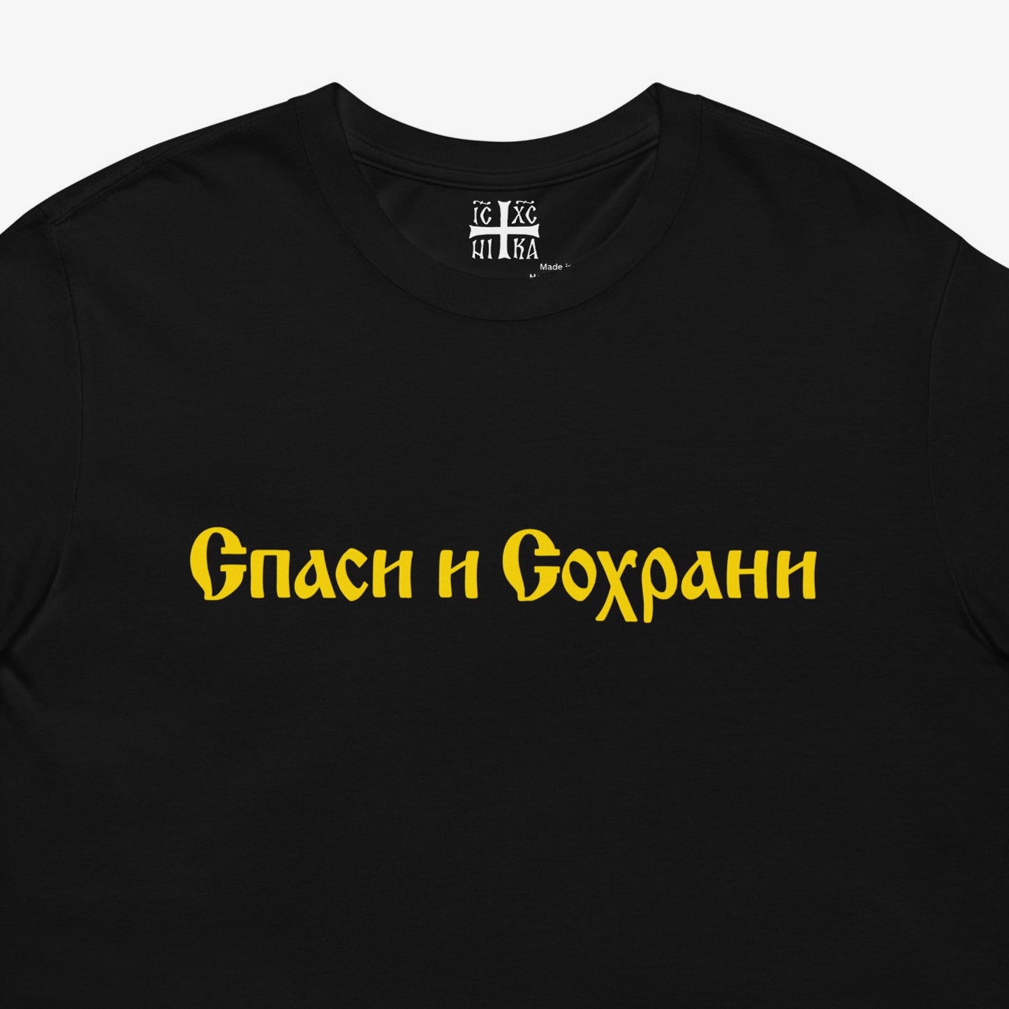 Black unisex tee with text Спаси и Сохрани (Spasi i Sohrani - Save and Protect) in Old Russian Cyrillic church calligraphy. Closeup photo with NIKA Orthodox Christian cross seen on the necktag. www.artsoviet.com