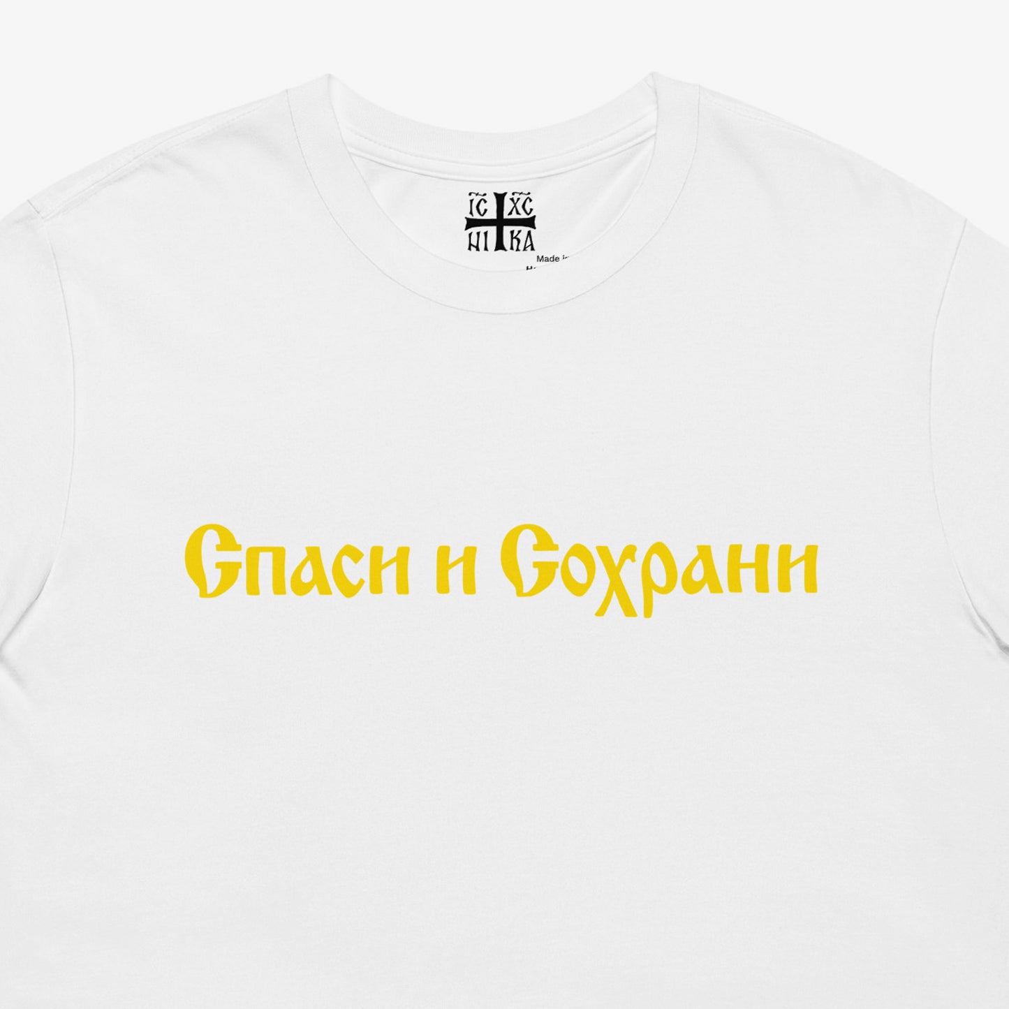 White unisex tee with text Спаси и Сохрани (Spasi i Sohrani - Save and Protect) in Old Russian Cyrillic church calligraphy. Closeup photo with NIKA Orthodox Christian cross seen on the necktag. www.artsoviet.com