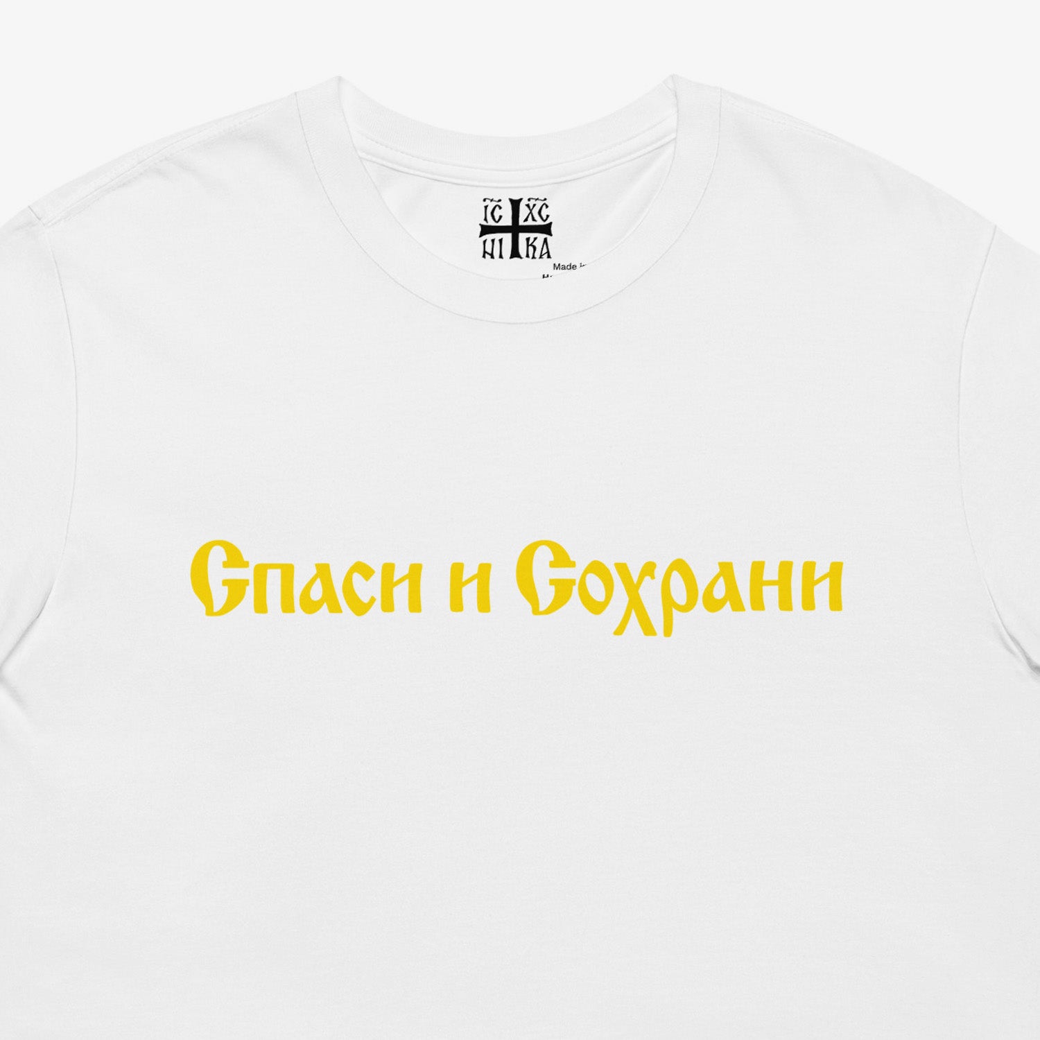 White unisex tee with text Спаси и Сохрани (Spasi i Sohrani - Save and Protect) in Old Russian Cyrillic church calligraphy. Closeup photo with NIKA Orthodox Christian cross seen on the necktag. www.artsoviet.com