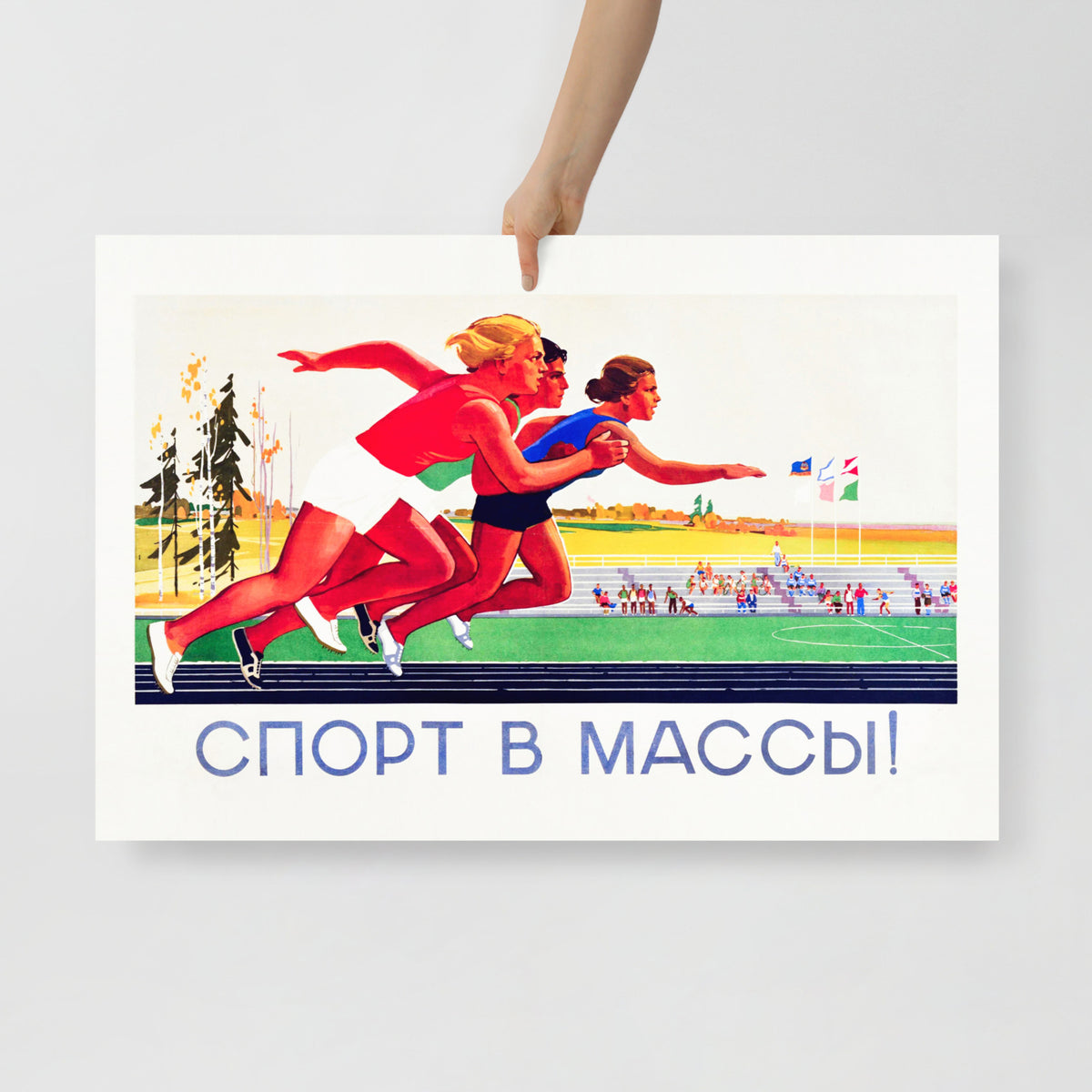 A hand holding large vintage Soviet poster with running girls and text 'Sport to the masses!'