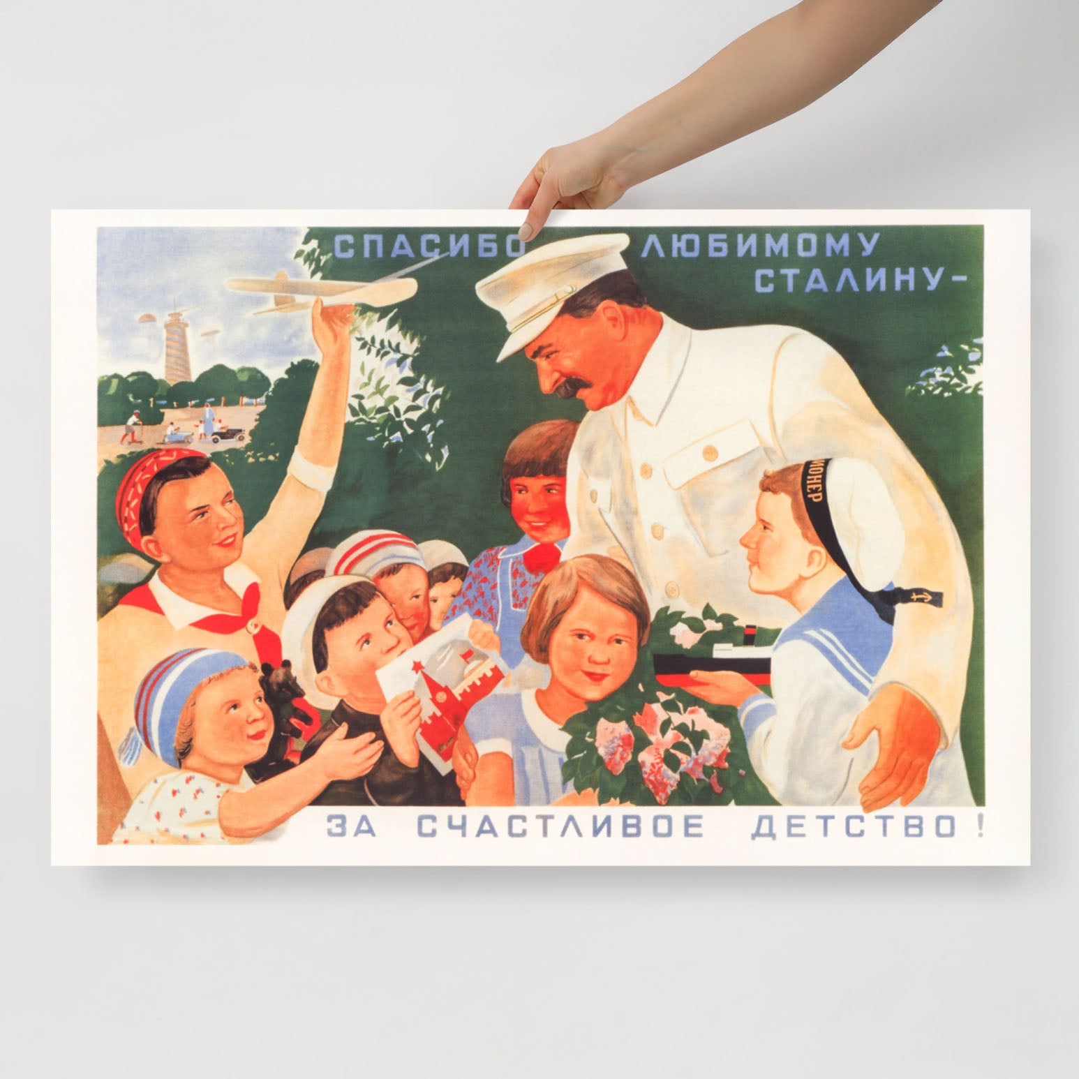 Front view of the poster showcasing the children and Stalin’s portrait, shot in a minimalist setting with natural lighting