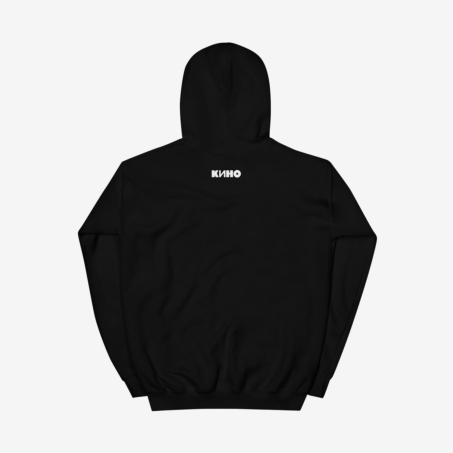 Rare archival photo of Viktor Tsoi in a yellow T-shirt against a white brick wall with a little KINO band logo under the photo, printed on the front of a heavyweight quality black unisex hoodie with a KINO logo on the back neck side, from GruppaKino.com. Back side.