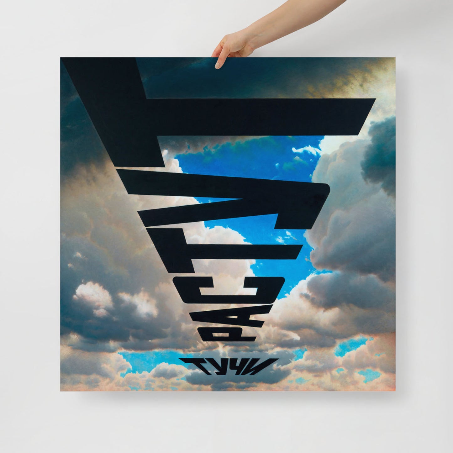 A hand holds large framed print of Erik Bulatov's painting 'Clouds are growing'. Closeup photo. www.artsoviet.com