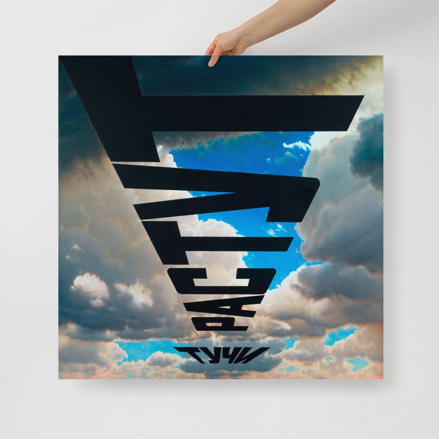 A hand holds large framed print of Erik Bulatov's painting 'Clouds are growing'. Closeup photo. www.artsoviet.com