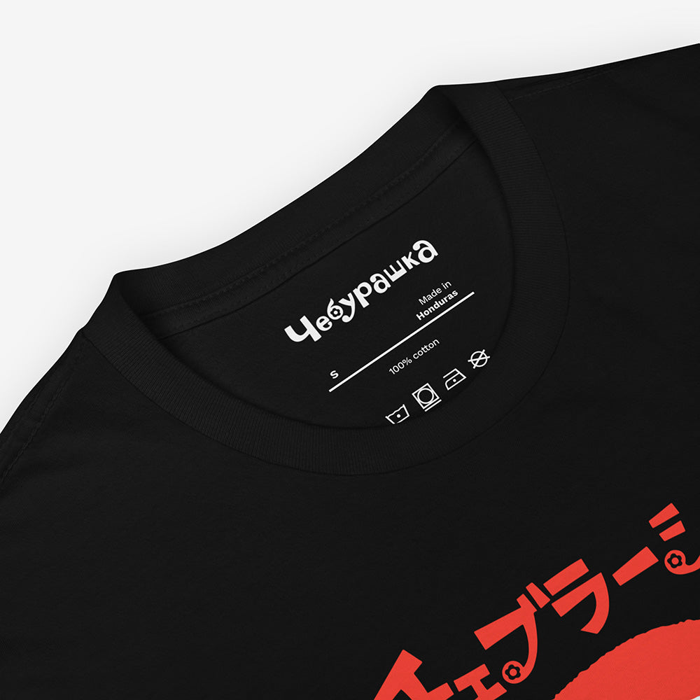 White unisex T-shirt with Soviet cartoon Cheburashka smiling and チェブラーシカ in Japanese above.
