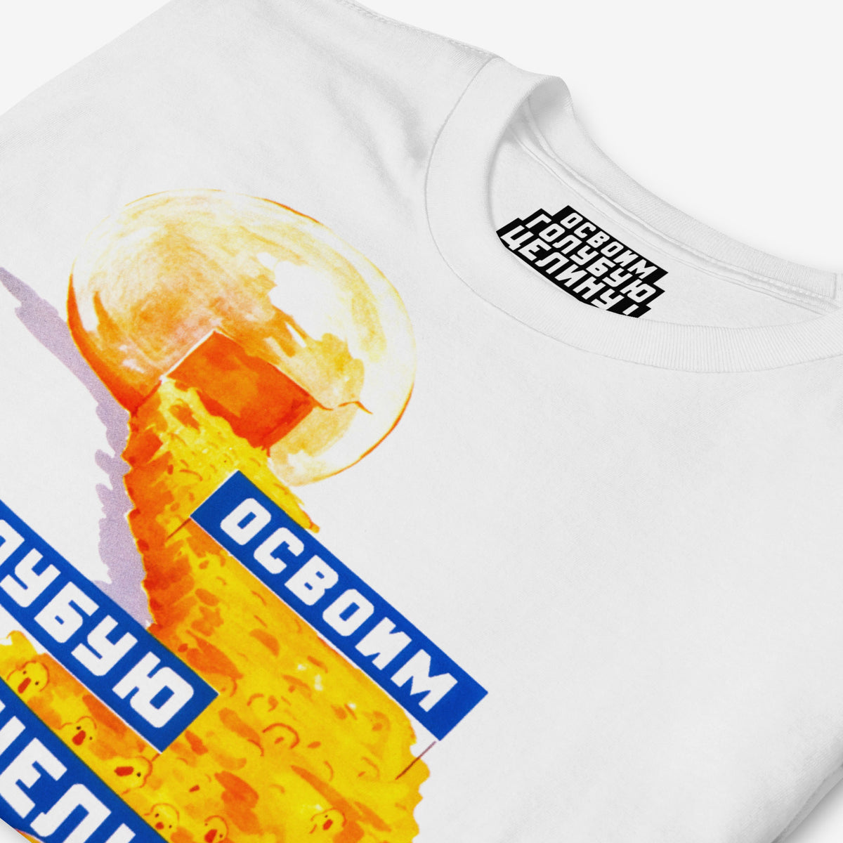White unisex t-shirt featuring original large print Soviet propaganda showing yellow ducklings marching from an egg carrying banners reading "Освоим голубую целину" (Let's Develop the Blue Virgin Lands), colourful Soviet agricultural development artwork featuring ducks and aquatic resource symbolism. Closeup print details